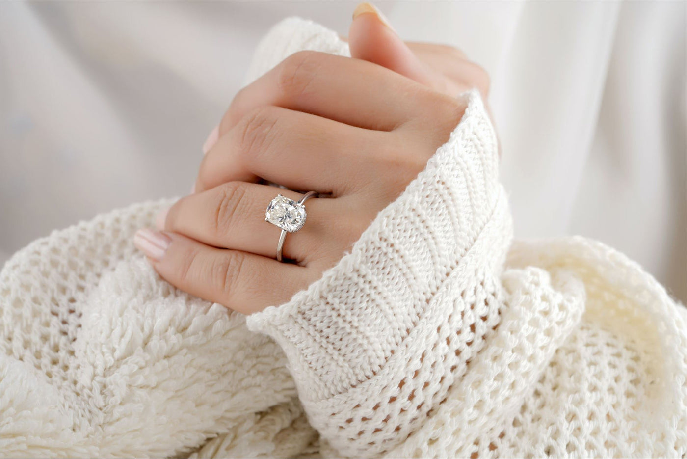 diamond ring on finger hands held together on white background