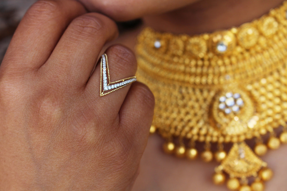 Diamond ring with a gold mangalsutra on the background worn by a woman